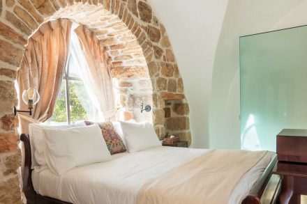 Authentic stone suite at Flora Valley Boutique Hotel, Ein Kerem, Jerusalem – king-size bed with an arched window and a magical view