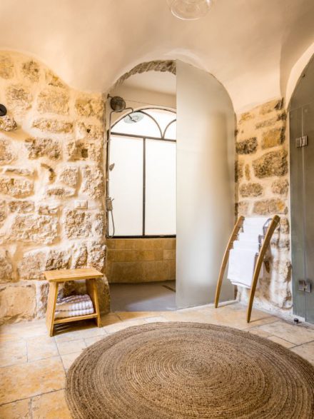 Authentic stone hallway with an arched door in the boutique suite at Flora Valley Boutique Hotel, Ein Kerem, Jerusalem – a blend of history and modern design