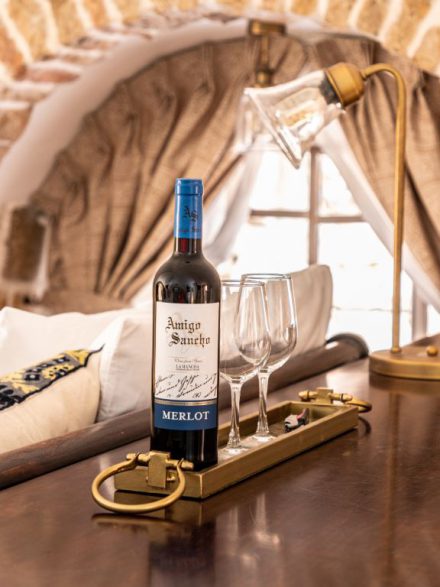 A bottle of red wine with two glasses on a golden tray in a boutique suite at Flora Valley Boutique Hotel, Ein Kerem, Jerusalem – the perfect treat for couples