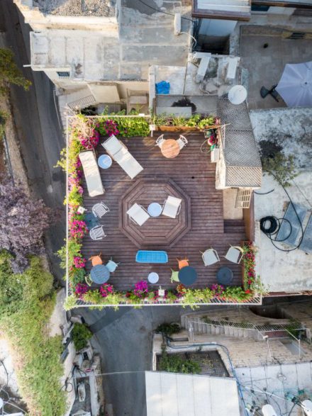 Aerial view of the rooftop at Flora Valley Boutique Hotel, Ein Kerem, Jerusalem – wooden deck, cozy seating areas, and blooming greenery.